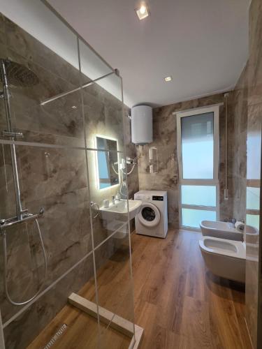 a bathroom with a shower and a toilet and a sink at Blue Harmony Lalzi Bay in Lalzit Bay