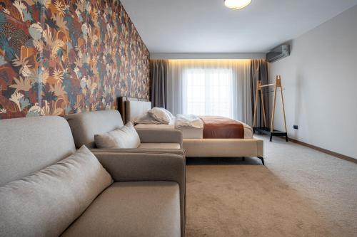 a living room with a couch and a bed at Downtown Apartments in Pristina