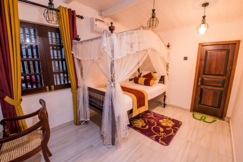 a bedroom with a bed with a canopy at Fortress de Jayaweera - Historic Villa Bentota - A proud legacy since 1889 in Bentota