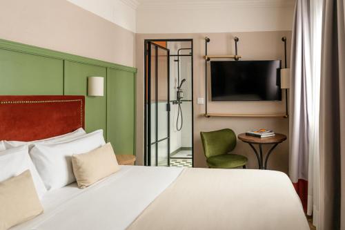 a hotel room with a bed and a television at The Honest Hotel & Apartments in Seville