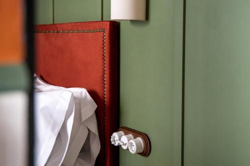 a book is hanging on a green wall at The Honest Hotel & Apartments in Seville
