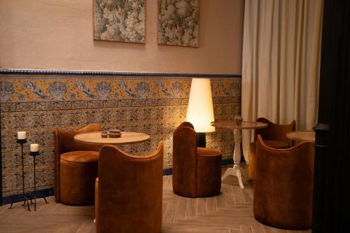 a room with a table and chairs and a lamp at The Honest Hotel & Apartments in Seville