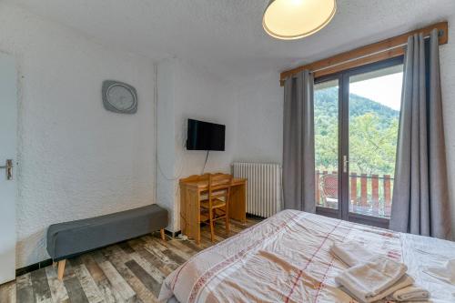 a bedroom with a bed and a tv and a window at Chambre d'hôte Gite Passoud in Oz