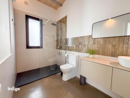 a bathroom with a toilet and a sink and a mirror at Villa Paz -Moderno Privado Nuevo Piscina Vistas a Golf y Lago in Ayamonte