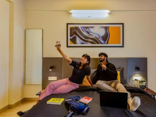 バンガロールにあるThe Hosteller Bangalore, Manyata Tech Parkのベッドに座っている男と女