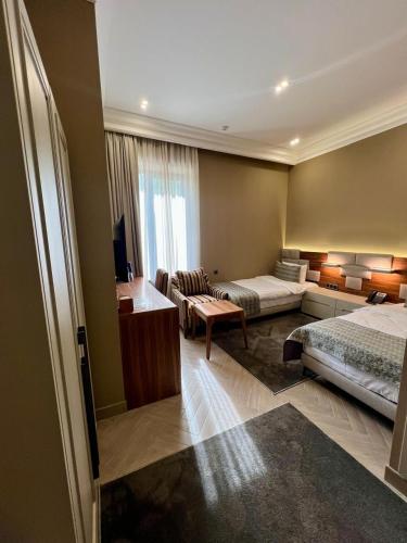 a hotel room with two beds and a couch at Plaza Viktoria Hotel Yerevan in Yerevan