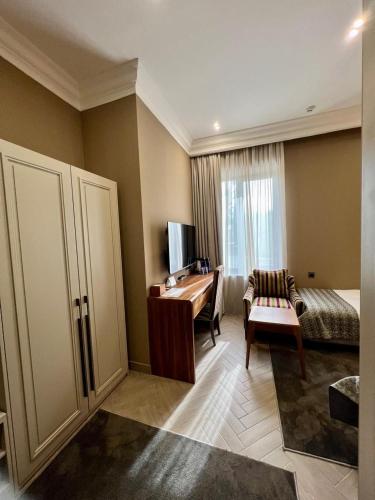 a living room with a piano and a desk at Plaza Viktoria Hotel Yerevan in Yerevan