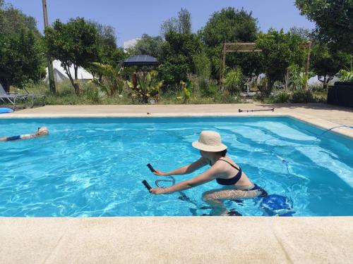 a woman sitting in a swimming pool with a hat at Casa Terapia in Loulé