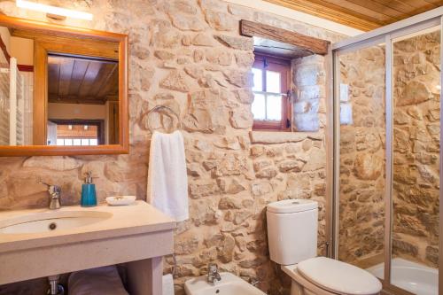 a stone bathroom with a toilet and a sink at Casal Frias in Barreira