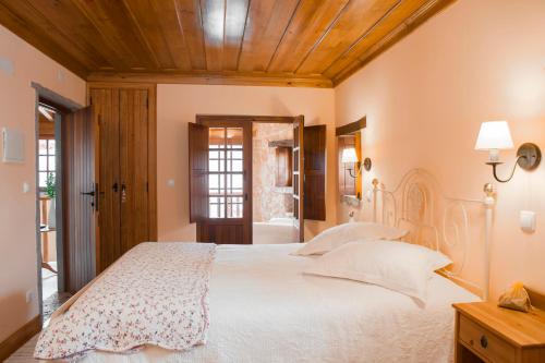a bedroom with a large bed with a wooden ceiling at Casal Frias in Barreira