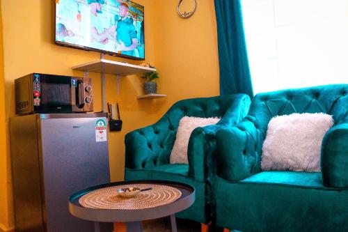a living room with a couch and a table and a television at Khalisee homes studio apartment 3 in Voi