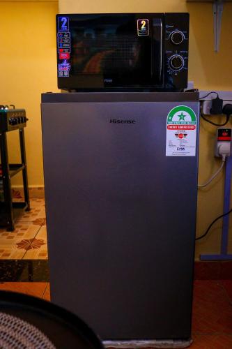 a microwave sitting on top of a refrigerator at Khalisee homes studio apartment 3 in Voi