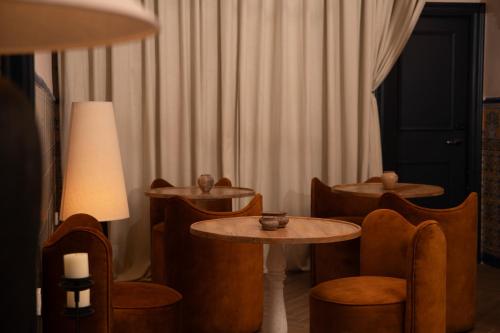 a room with tables and chairs and a lamp at The Honest Hotel & Apartments in Seville