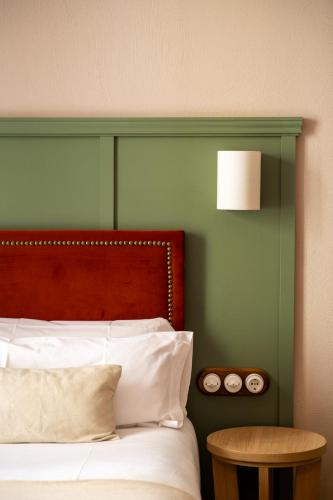 a bedroom with a bed with a red headboard and a table at The Honest Hotel & Apartments in Seville