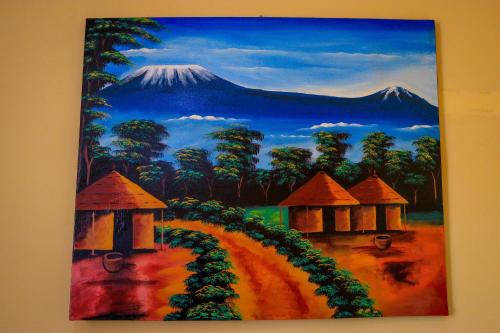 a painting of a mountain with houses and trees at Khalisee homes studio apartment 3 in Voi