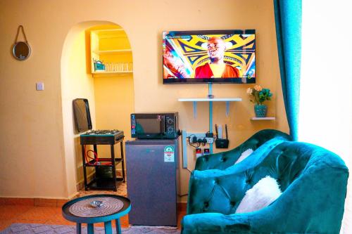 a living room with a couch and a television at Khalisee homes studio apartment 3 in Voi