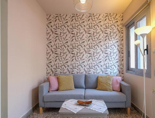 a living room with a blue couch and a wall at The Museum View Suite in Heraklio Town