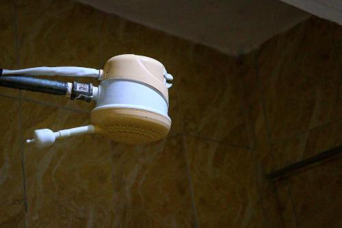 a hair dryer hanging from a wall in a bathroom at Khalisee homes studio apartment 3 in Voi