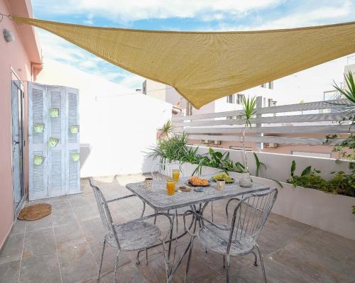 a patio with a table and chairs on a balcony at The Museum View Suite in Heraklio Town
