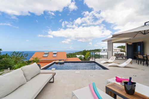 a villa with a swimming pool and a patio at Villa Pomelia in Le Carbet