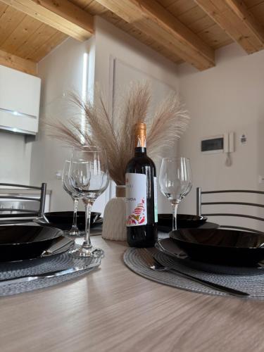 a bottle of wine sitting on a table with glasses at Francesco's house-airport in Bologna