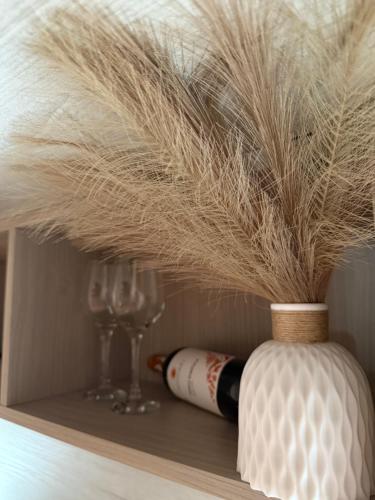 a bottle of wine and glasses on a shelf at Francesco's house-airport in Bologna