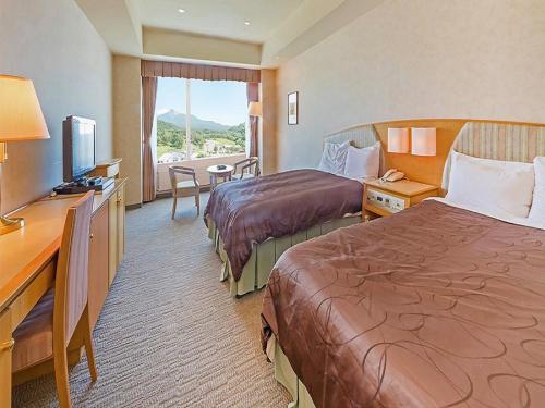 a hotel room with two beds and a television at LiVEMAX RESORT Hakodate Greenpia Onuma in Mori