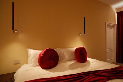 a bedroom with a bed with red pillows on it at Leano Agriresort in Piazza Armerina