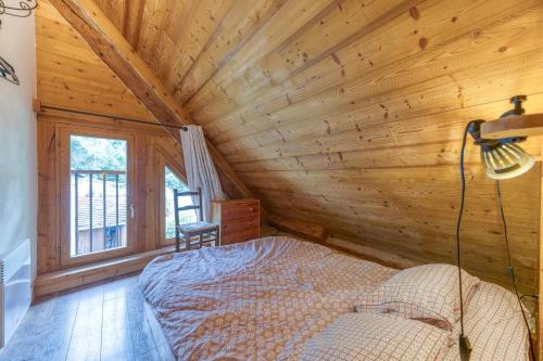 a bedroom in a log cabin with a bed and a window at Auberge Passoud 203 in Vaujany