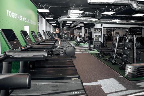 a gym with rows of treadmills and machines at Village Hotel Bracknell in Bracknell