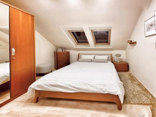 a bedroom with a large bed and two windows at Izabelin Apartment in Swarzędz