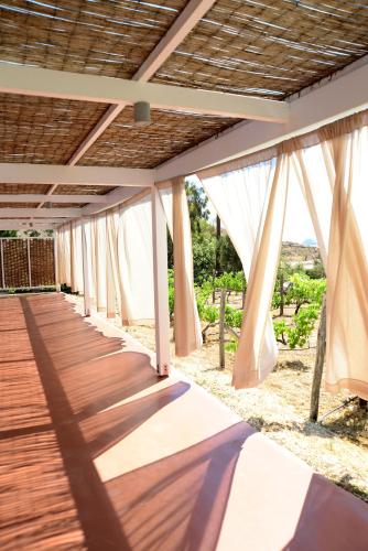 a wooden walkway with white curtains on it at ANEMI Folegandros in Karavostasi