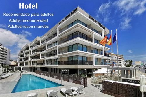 a hotel with a swimming pool in front of a building at Hotel & Spa Castillo de Peñíscola 4* Sup in Peñíscola