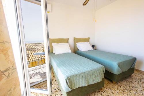 two beds in a room next to a mirror at Family House in Lakones in Paleokastritsa