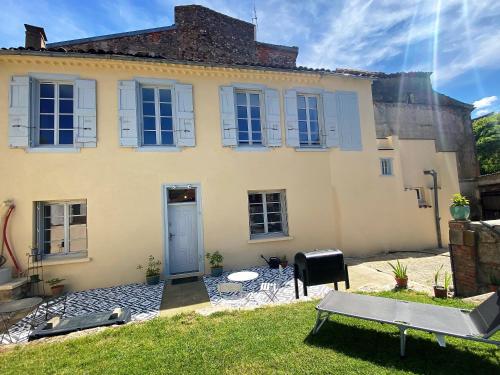 a large yellow house with a blue door at 2 pièces élégant calme central parking sur place in Foix