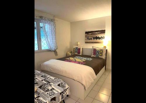 a bedroom with two beds and a window at Grabels Soleil Calme & Piscine in Grabels