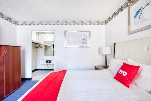 a bedroom with a large white bed with red pillows at Travelers Inn By OYO, Templeton VA in Petersburg