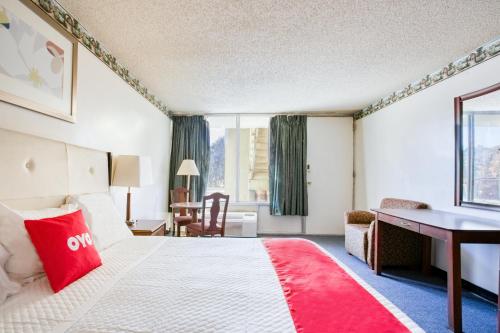 a hotel room with a large bed and a desk at Travelers Inn By OYO, Templeton VA in Petersburg