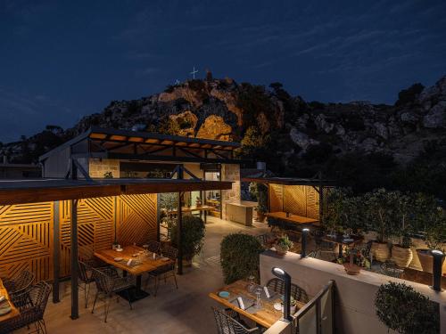 a restaurant with tables and chairs and a mountain at Casa D'Irene Deluxe Hotel in Falasarna