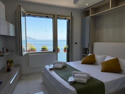 a bedroom with a bed with a view of the ocean at Paradise By The Sea in Taormina