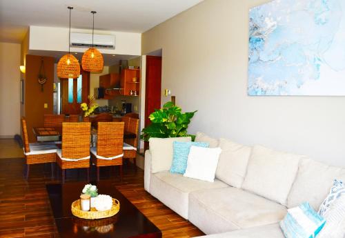 a living room with a white couch and a table at Departamento Mayan Lakes T9 - Albercas, club de playa, tenis, pádel y más in Acapulco