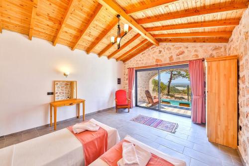 a living room with a bed and a large window at Spacious 2BR Stone Villa with Pool & BBQ in Kalkan