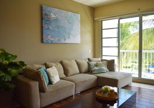 a living room with a couch and a table at Departamento Mayan Lakes T9 - Albercas, club de playa, tenis, pádel y más in Acapulco