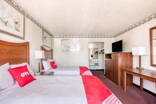 a hotel room with two beds and a desk at Travelers Inn By OYO, Templeton VA in Petersburg