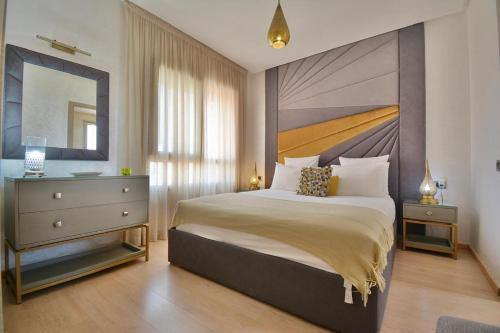 Un dormitorio con una cama grande y un espejo. en Jade Haven 2 Bed Apt golf view, en Marrakech