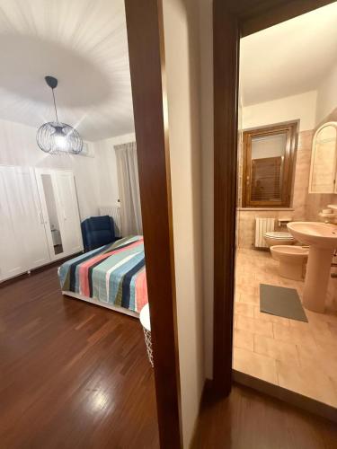 Un dormitorio con una cama y un baño con lavabo. en Blue and Green Apartment, en San Benedetto del Tronto