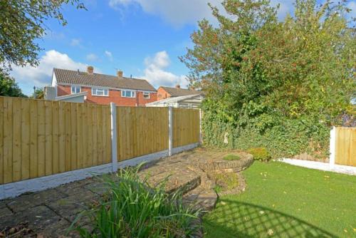 a backyard with a wooden fence and a yard at MODERN 3 BEDROOM PROPERTY WITH FREE DRIVEWAY PARKING by SHIRE STAYS in Shrewsbury