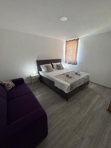 a bedroom with a bed and a couch at Apartments Lucijan Međugorje in Međugorje