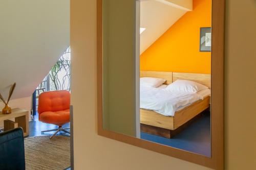 a mirror in a room with a bed and a chair at Schanzenstern Altona GmbH in Hamburg