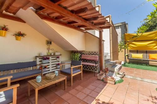 a patio with a wooden pergola and a bench at Charlotte Apartment - For family and groups in Porto Torres